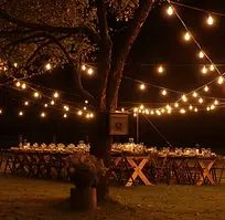 Outdoor dinner table under warm evening lights